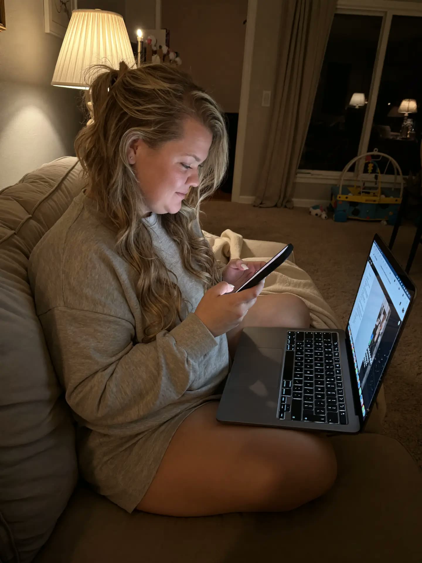 Kendyll on the couch with her laptop after the girls are in bed