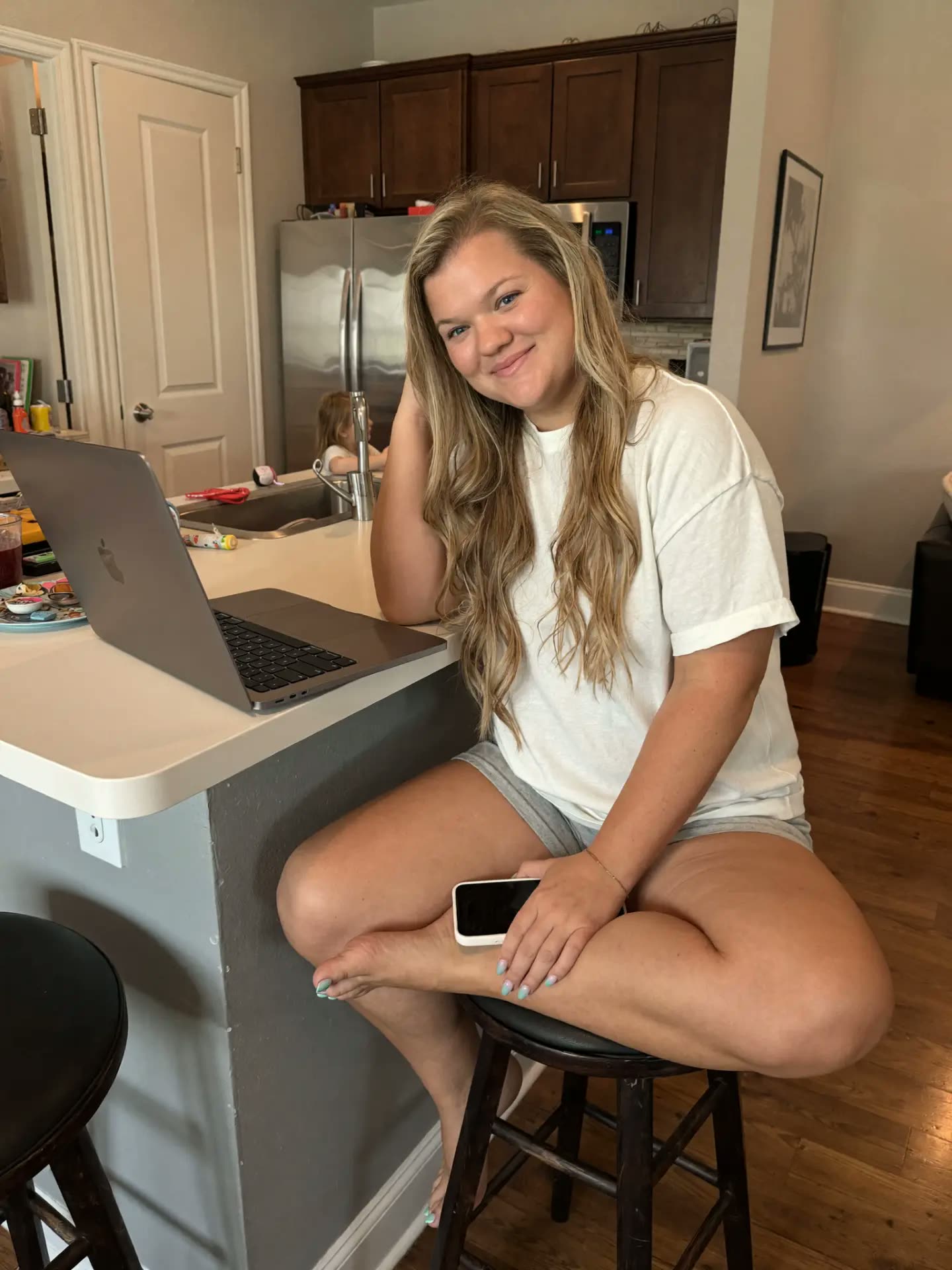 Kendyll at her kitchen counter with her laptop and phone